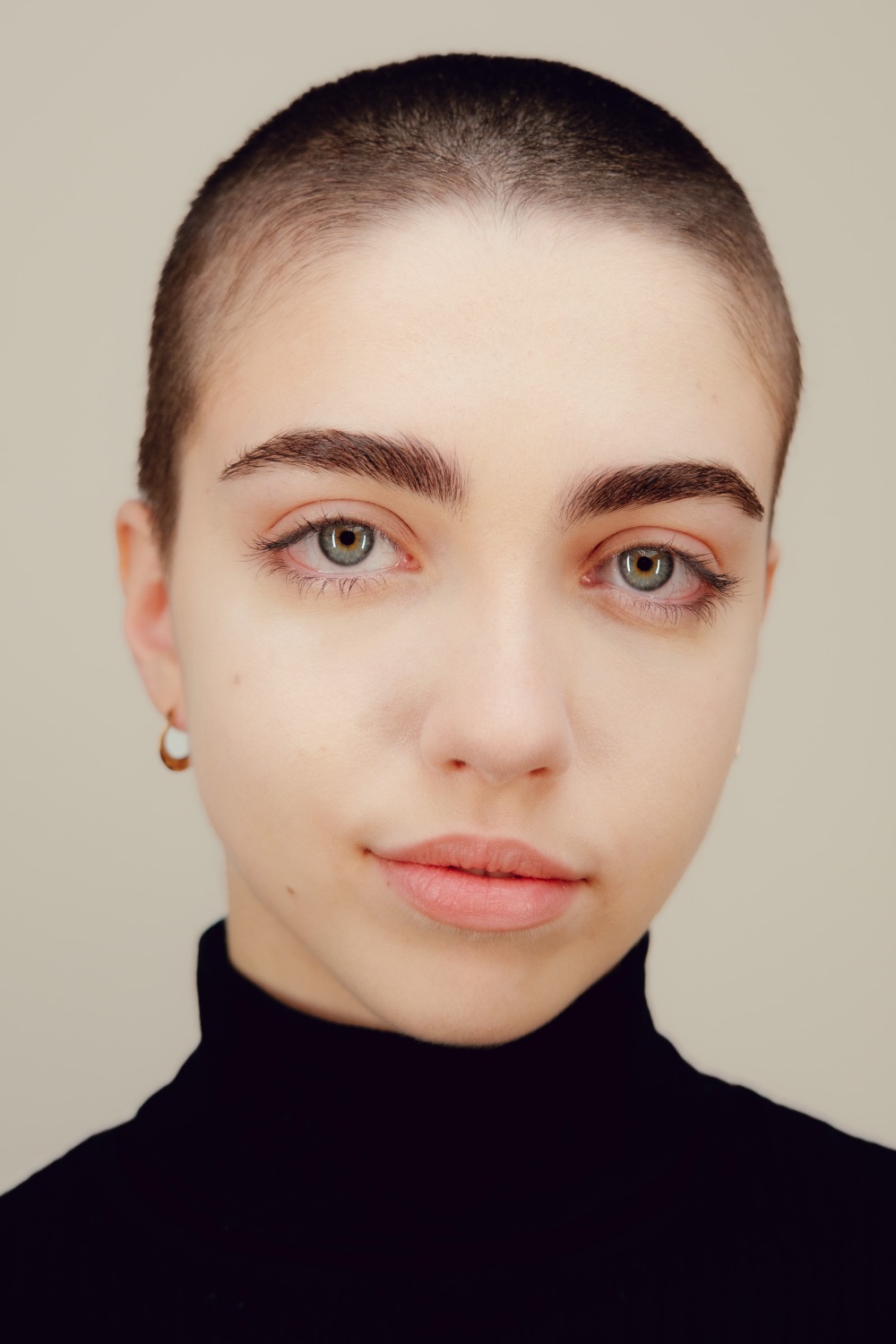 Studio portrait of a woman in soft warm light, direct gaze